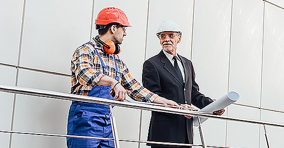 standing industrial engineers blue vests helmets