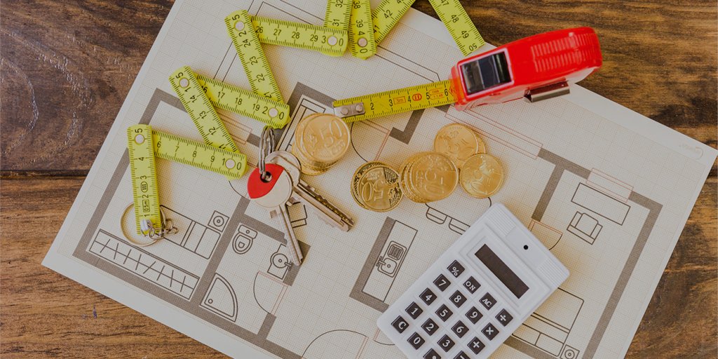 elevated view measure tape stacked coins key calculator blueprint overlay